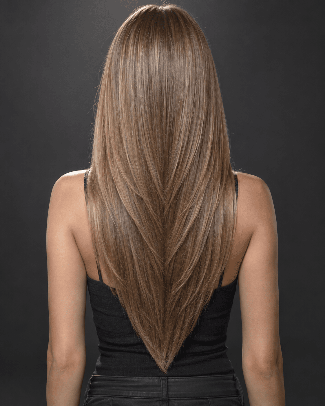 Back view of long straight hair cut in a dramatic V-shaped layered silhouette.