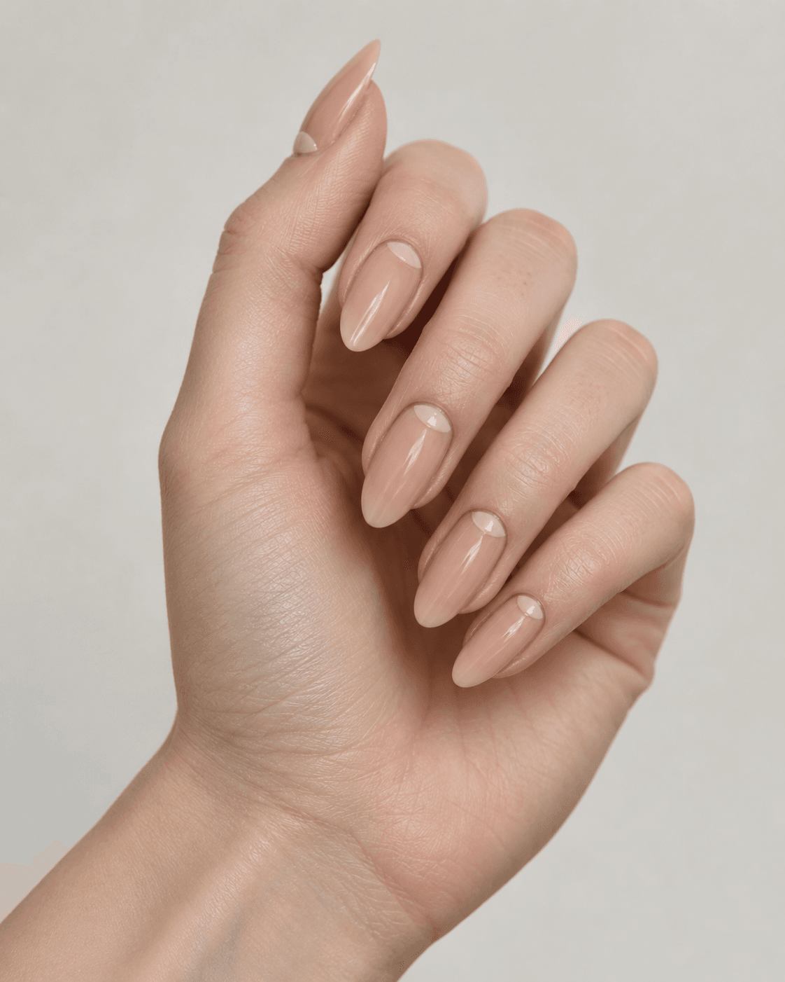 Hand with almond acrylic nails featuring delicate negative space detailing.