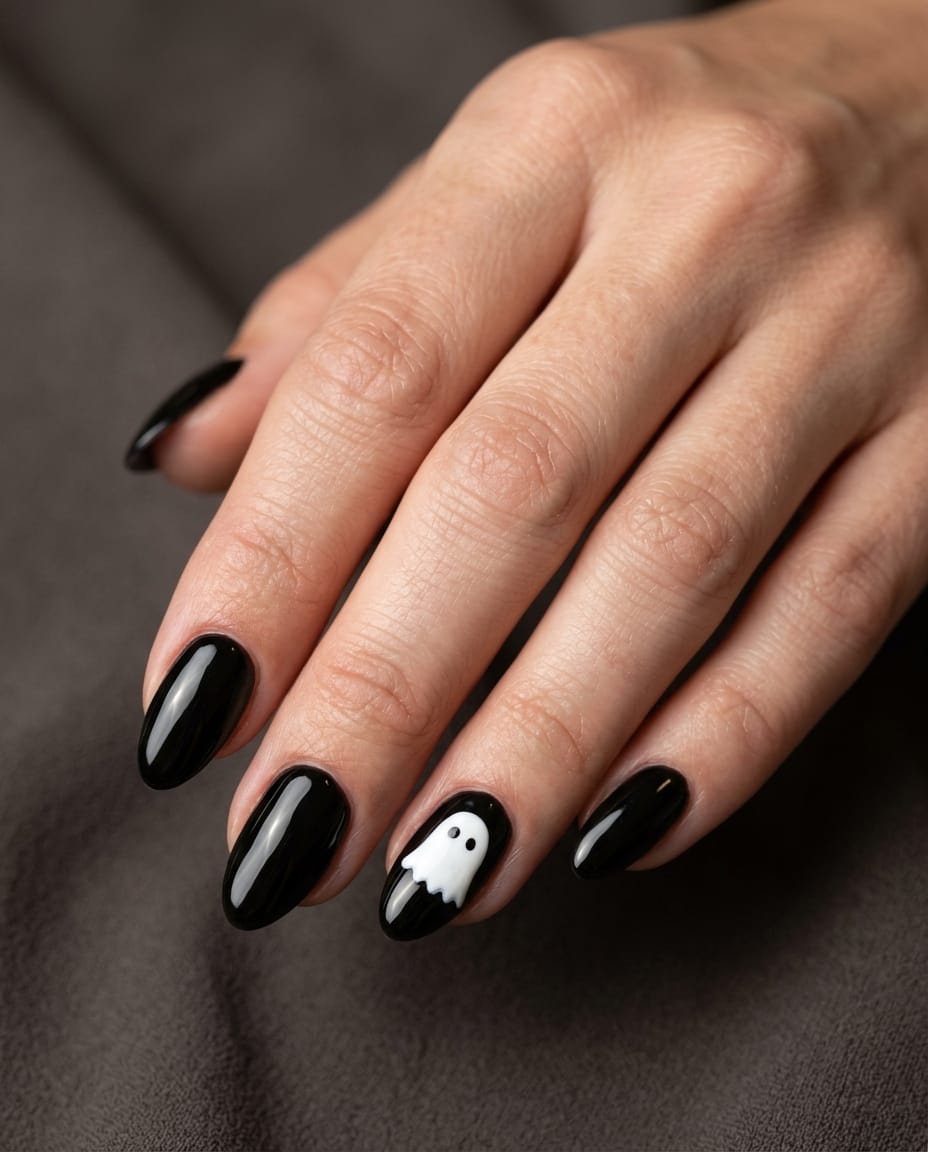 Hand with black acrylic nails and a simple white ghost silhouette accent nail