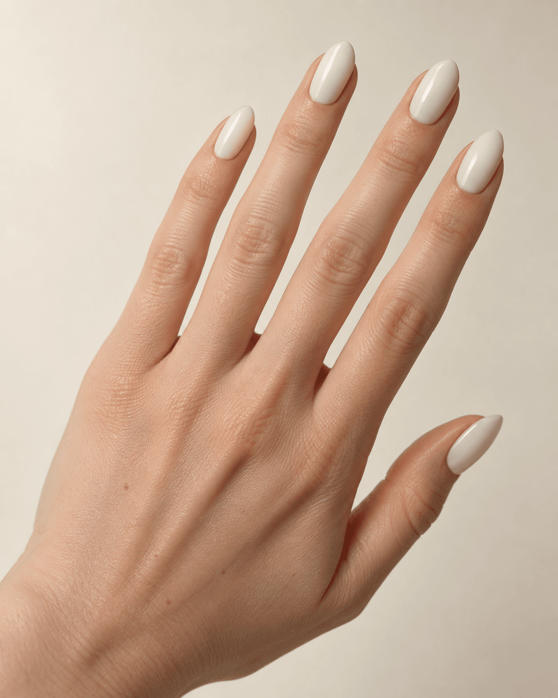Hand with classic oval-shaped ivory acrylic nails.