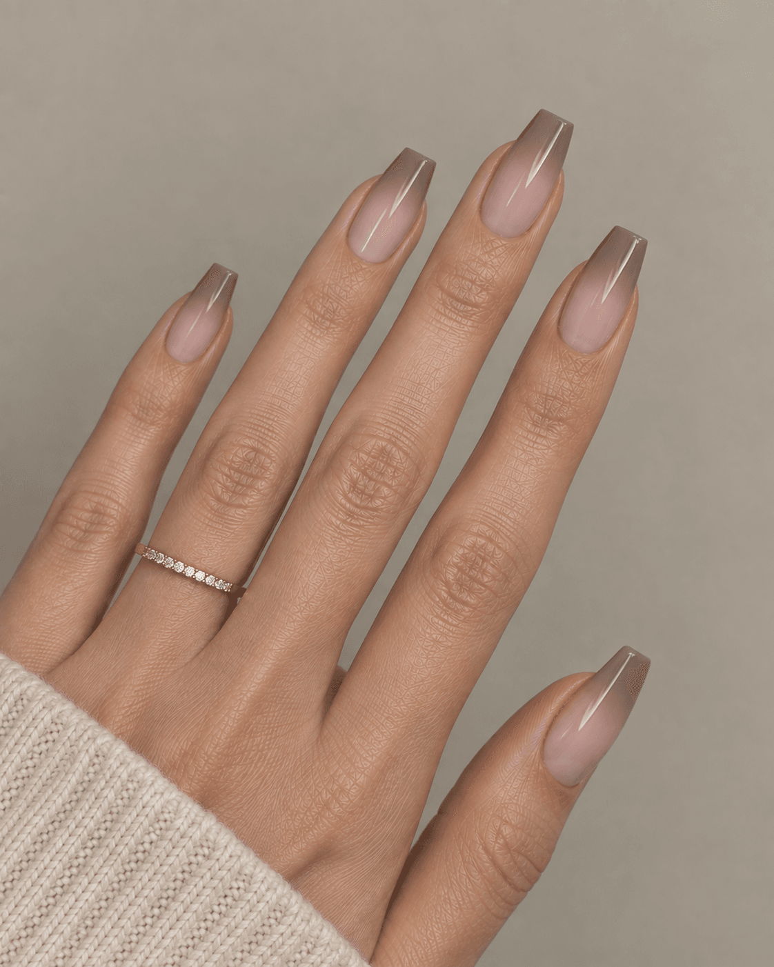 Hand with ombré nude-to-taupe gradient acrylic nails.