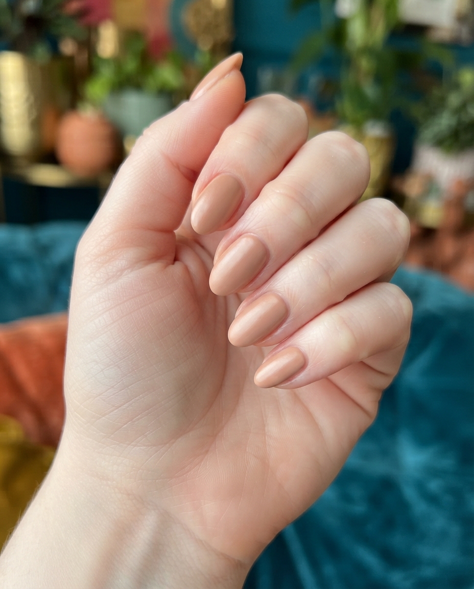 Hand with satin-finish nude oval acrylic nails