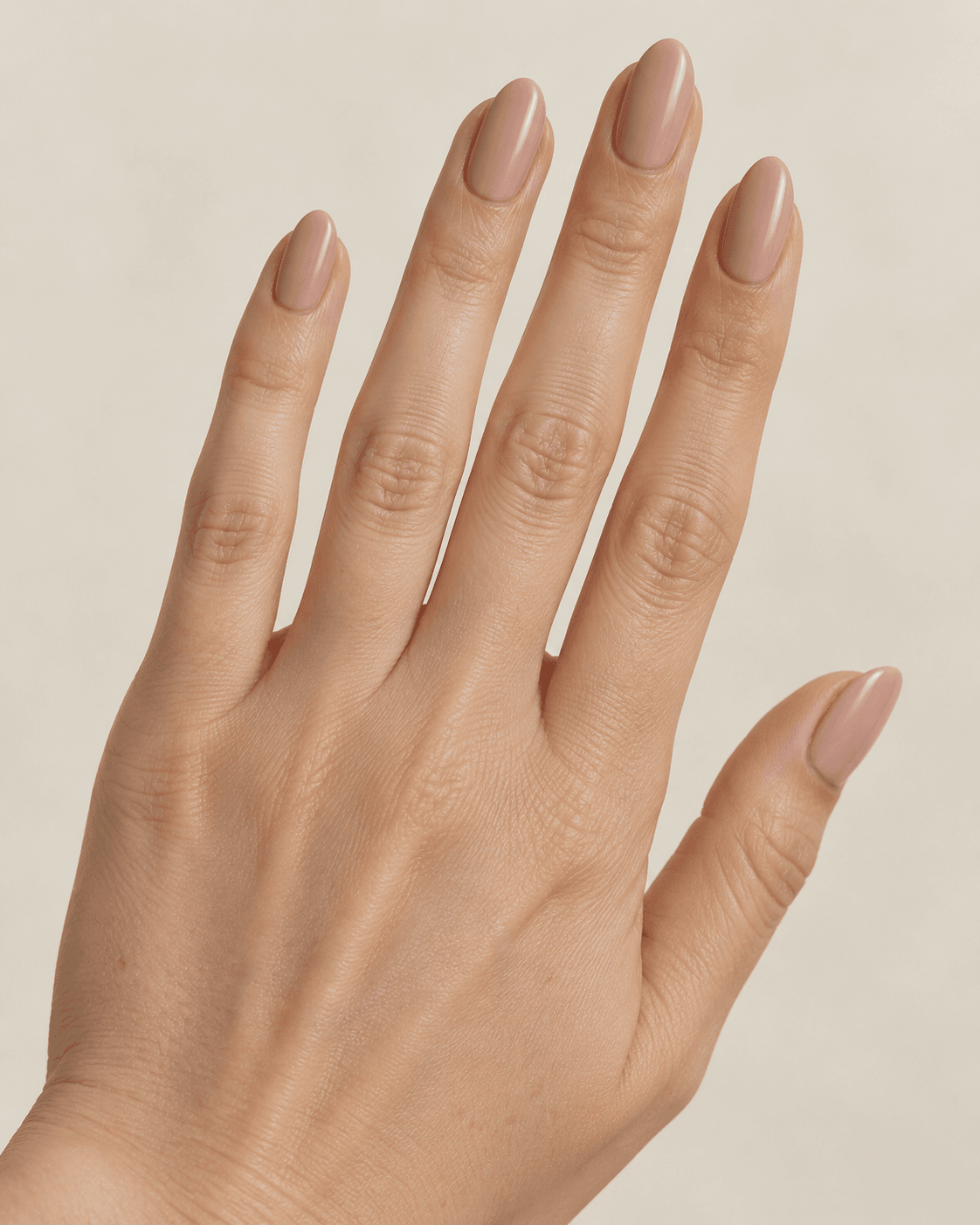 Hand with satin-finish nude oval acrylic nails.