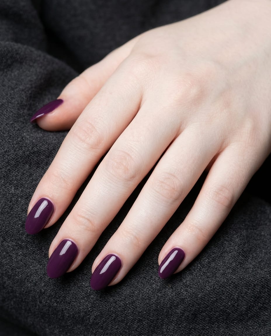 Hand with solid deep purple oval acrylic nails