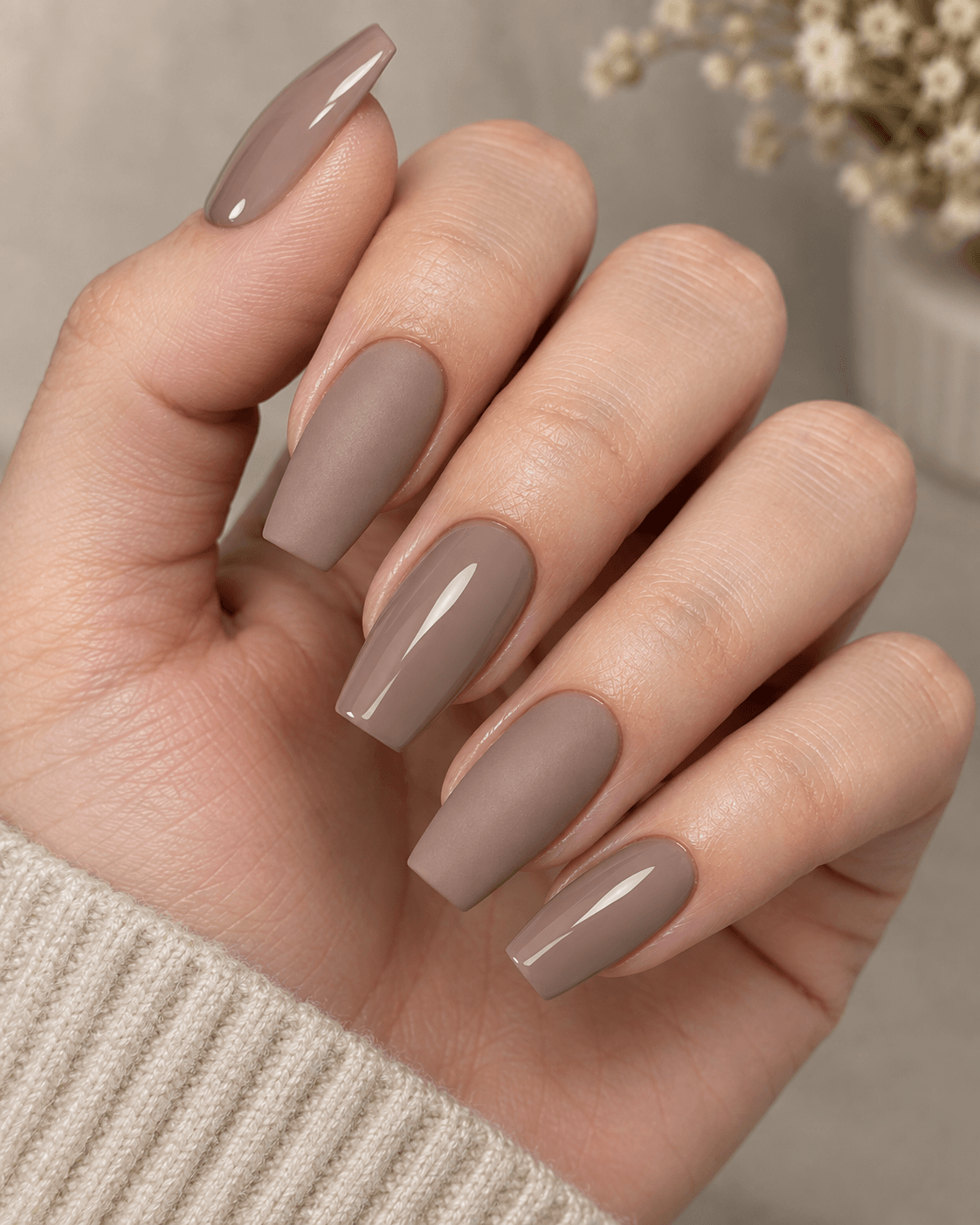 Hand with taupe acrylic nails alternating between matte and glossy finish.