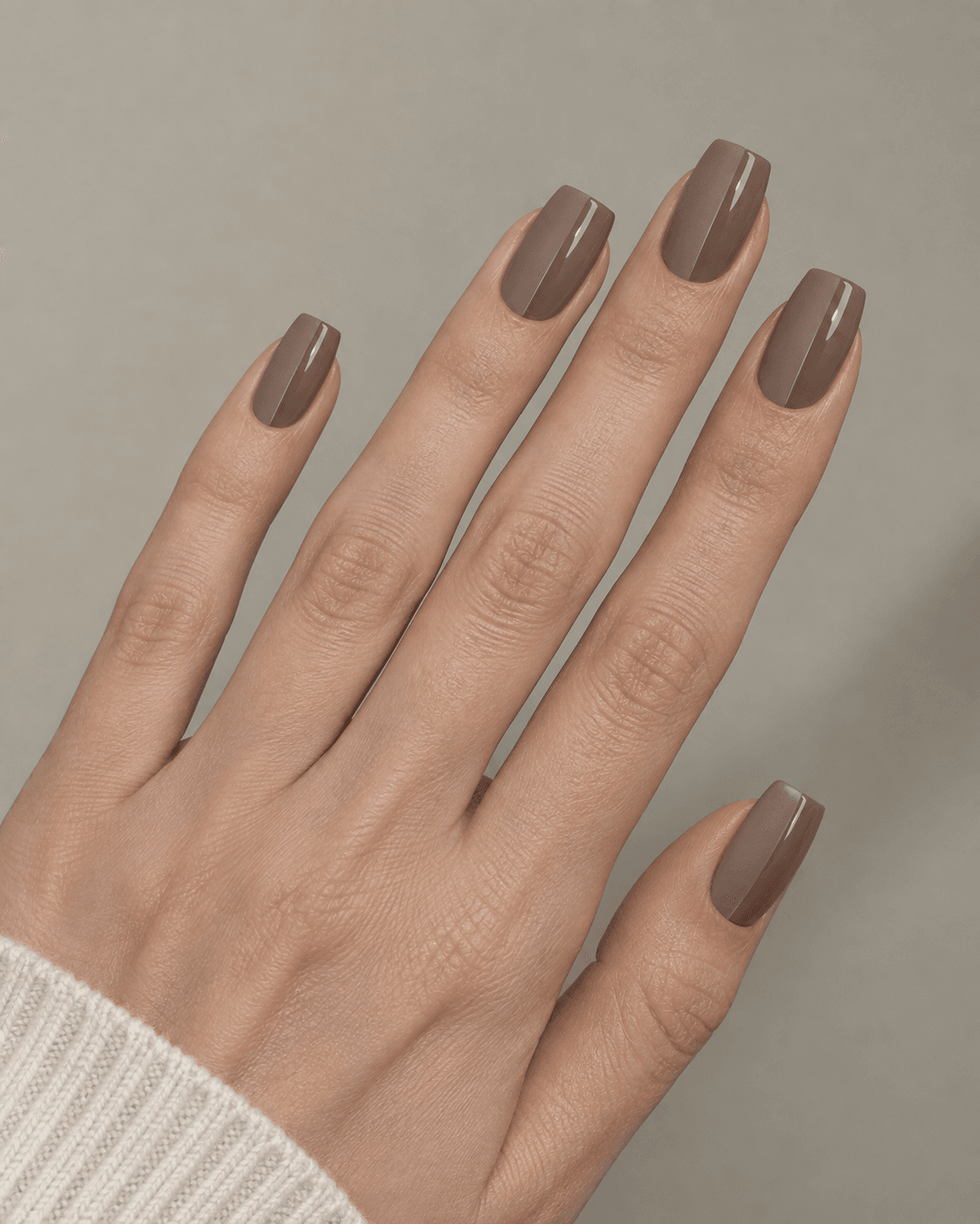 Hand with taupe acrylic nails featuring a matte-and-glossy vertical split design.
