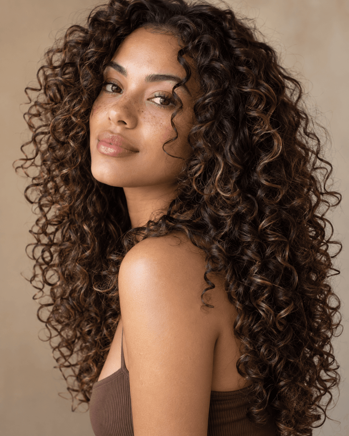 Long curly hair layered and cut dry for defined curl shape.